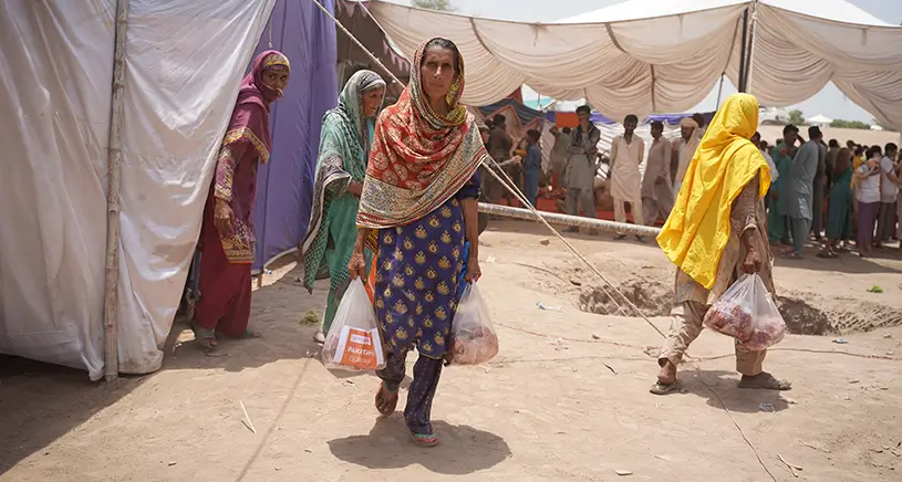 A woman carries two bags of meat supplied by Penny Appeal.