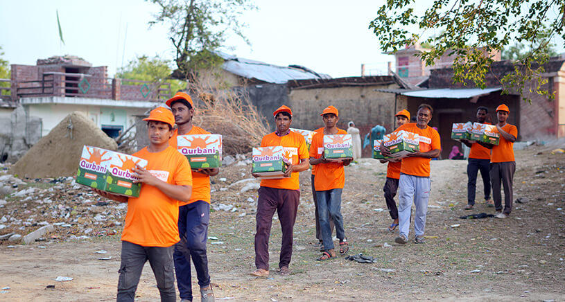 A group of Penny Appeal aid workers carry boxes of Qurbani meat ready to deliver in India.