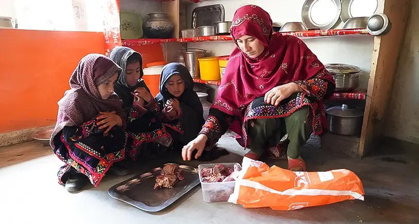 A woman cooking food for her children.