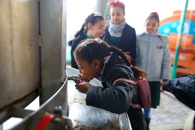 Girl drinking from a water tap