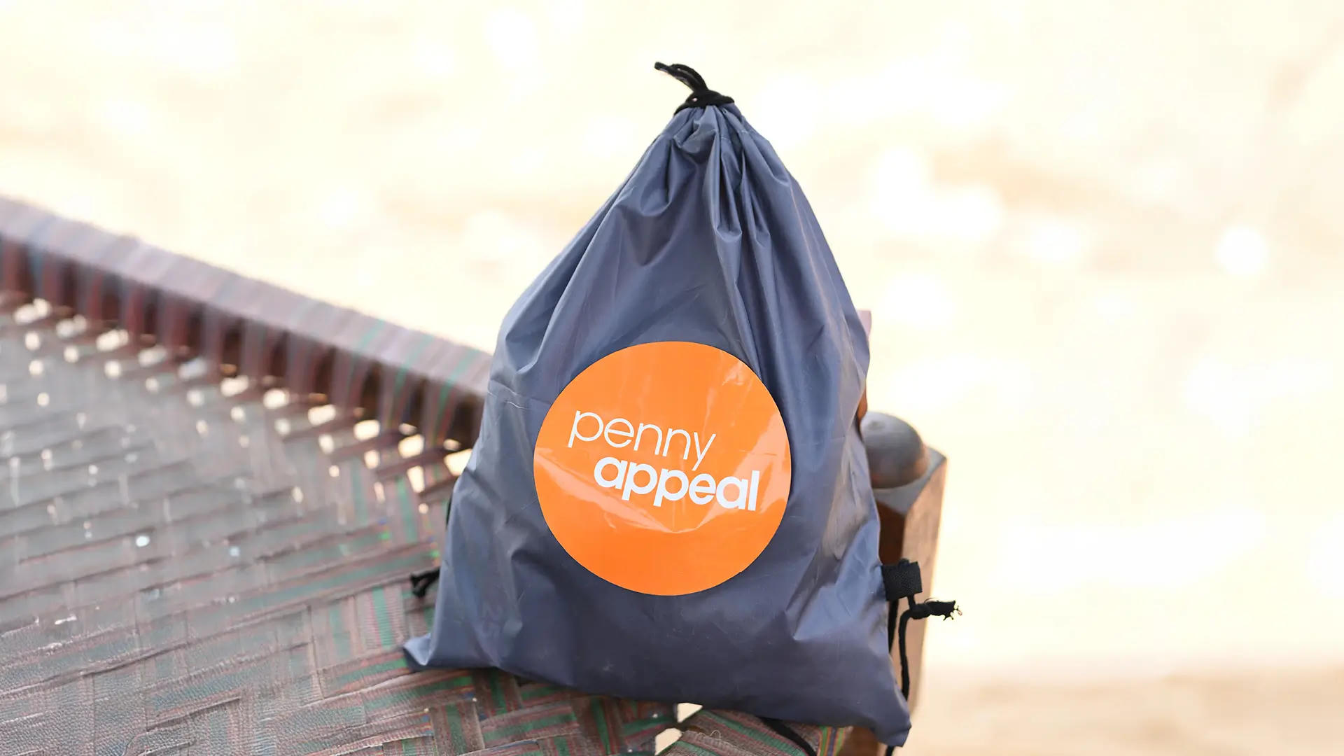 A close up of the Dignity Kit provided by Penny Appeal in a bag, with the orange logo showing on the front.