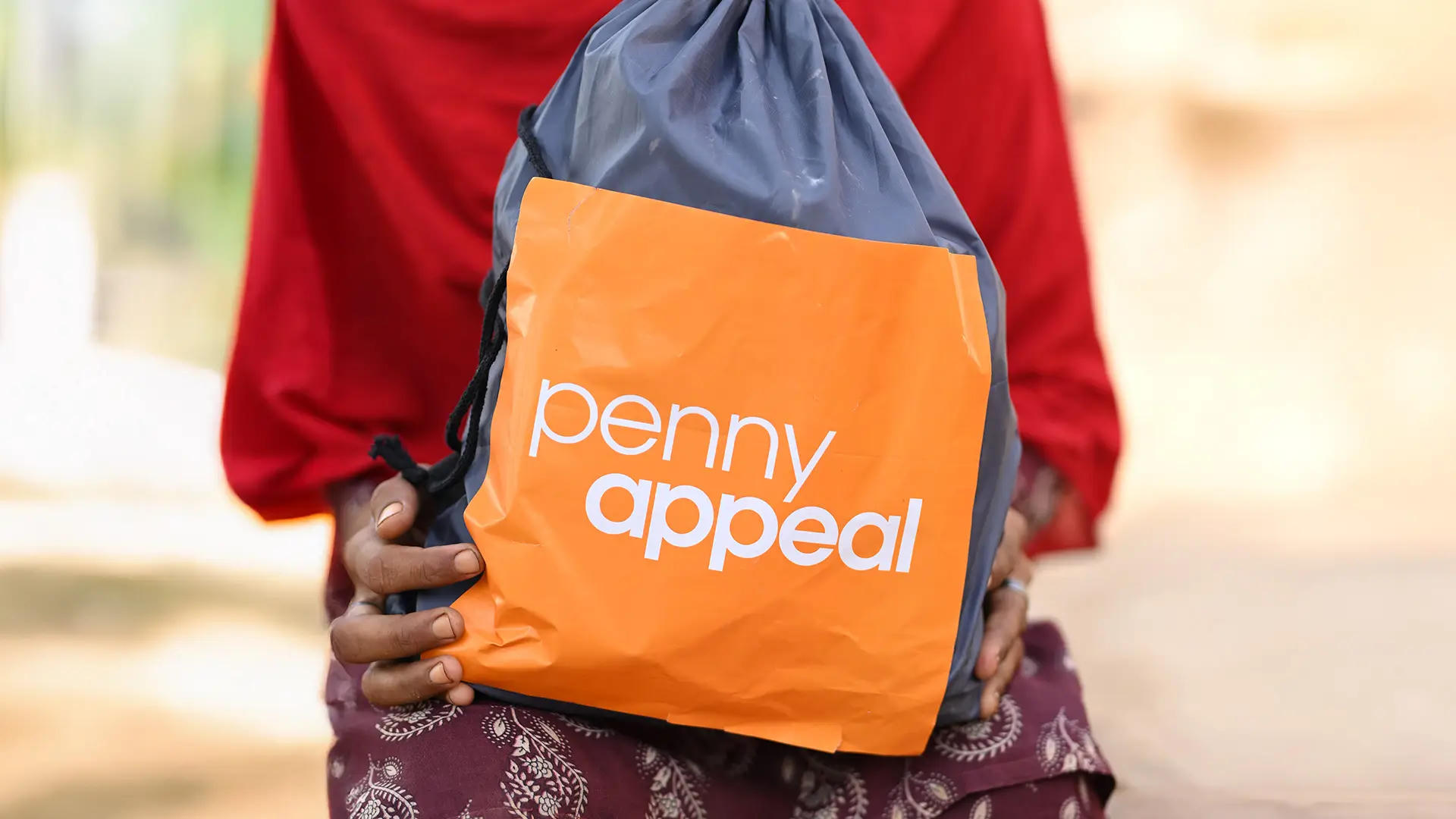 A close up of a lady's hands holding the Dignity Kit provided by Penny Appeal.
