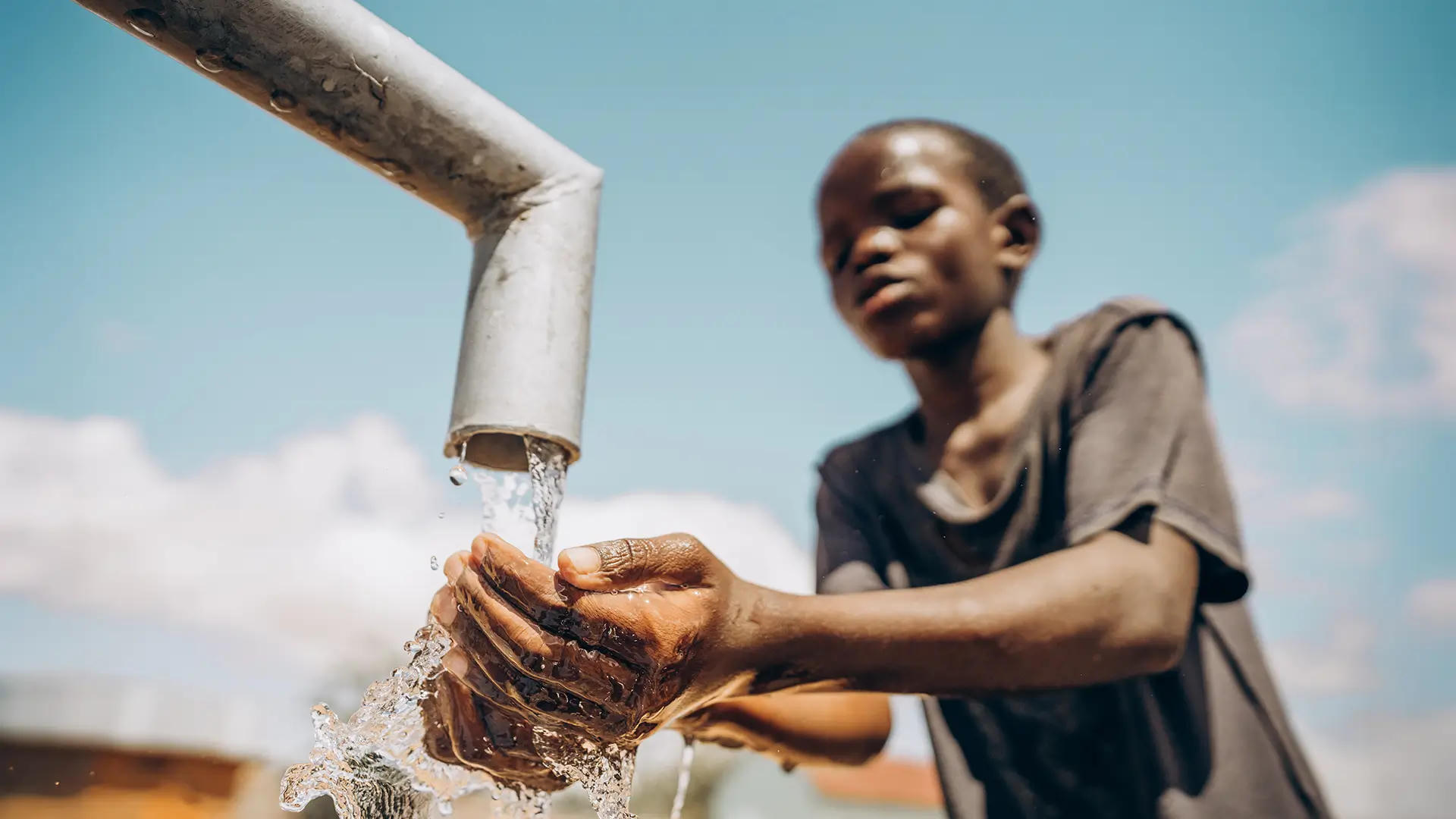 A boy washes his hands under a running tube well, part of Penny Appeal’s Thirst Relief clean water initiative.