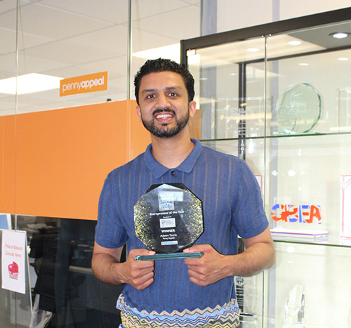 adeem holding the entrepreneur of the year award